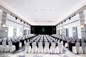 une grande chambre avec des rangées de chaises et une scène dans l'établissement Holiday Inn Taiyuan City Center, à Taiyuan