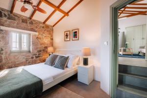 um quarto com uma cama e uma parede de tijolos em Unique Cunda Experience Stone House w Private Bay 