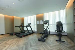 a gym with treadmills and ellipticals in a room at Holiday Inn Taiyuan City Center in Taiyuan