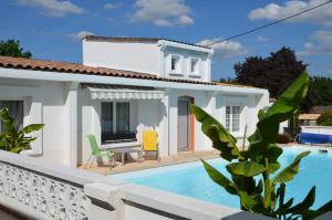 a villa with a swimming pool in front of a house at Jardin de Marceau in Blasimon