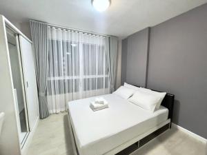 a small bedroom with a white bed and a window at Condo in Town in Chiangmai in Chiang Mai