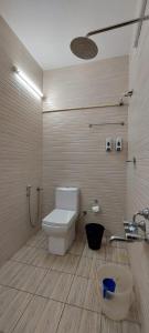 a bathroom with a toilet and a shower and a sink at The Marine Pride Beach Resort & Spa in Varkala