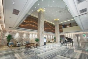 a lobby with a piano and tables in a building at Holiday Inn Taiyuan City Center in Taiyuan