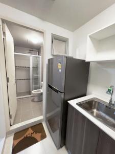a small kitchen with a sink and a refrigerator at Condo in Town in Chiangmai in Chiang Mai