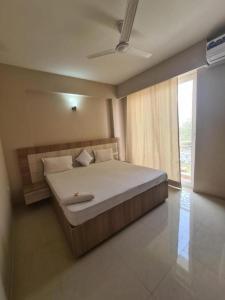a bedroom with a large bed and a large window at Lord Krishna Place in Vrindāvan