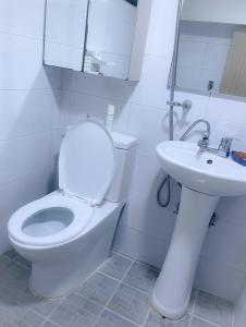 a white bathroom with a toilet and a sink at ARMYCasa with 2 rooms and 1 bathroom in Seoul