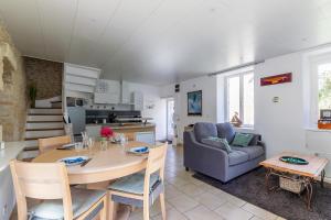 uma cozinha e sala de estar com uma mesa e um sofá em La Rochambelle - Charmante maison de pêcheurs em Bernières-sur-Mer