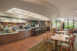 a restaurant with tables and chairs and a counter at Courtyard by Marriott Middletown Goshen in Middletown