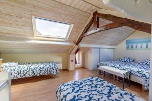 Cette chambre mansardée comprend 2 lits et une fenêtre. dans l'établissement La Rochambelle - Charmante maison de pêcheurs, à Bernières-sur-Mer
