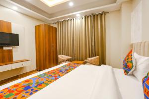 een hotelkamer met een bed en een televisie bij FabHotel Raahi Retreat in Gurgaon