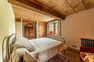 een slaapkamer met een bed in een kamer met houten plafonds bij Colombier - Charmante maison avec jardin 