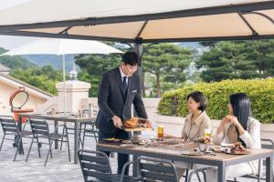 a man serving a plate of food at a restaurant at Oak Valley Resort in Wonju