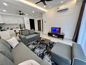 Una sala de estar con dos sofás y un televisor. en Middle Town Breezy Stay {Novo8} 4pax-Wifi, en Melaka