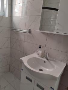 bagno bianco con lavandino e specchio di Bora apartman a Soko Banja