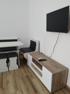 un soggiorno con tavolo e TV a parete di Bora apartman a Soko Banja
