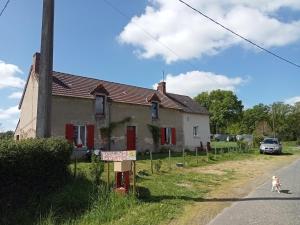 a dog walking past a house on the side of the road at Studio Les Pourettes in Feusines
