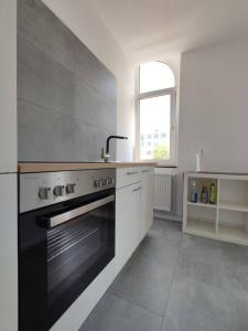 een keuken met een fornuis, een wastafel en een raam bij 'BRIGHT 201' Moderne, helle Wohnung in BI Zentrum, 400 m bis Lokschuppen, Smart-TV, WLAN in Bielefeld