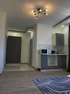 a living room with a kitchen and a ceiling fan at Astina Hotel in Astana