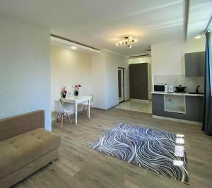 a living room with a couch and a table and a kitchen at TAMYRLY Astana in Astana