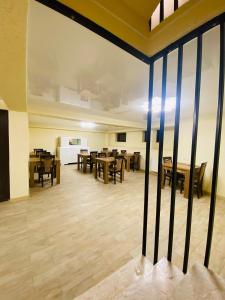 a dining room with wooden tables and chairs at HOTEL SUNRISE in Kutaisi