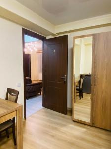 a room with a wooden door and a table and chairs at HOTEL SUNRISE in Kutaisi