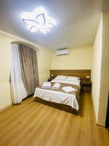 a bedroom with a bed and a light on the ceiling at HOTEL SUNRISE in Kutaisi