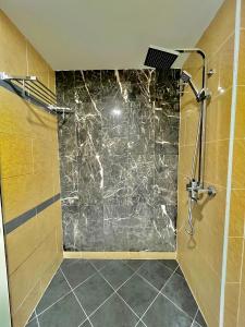 een badkamer met een douche en een glazen deur bij Melur Inn in Cameron Highlands