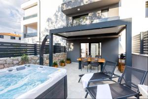 a hot tub in the backyard of a house at Superior Apartments in Malinska