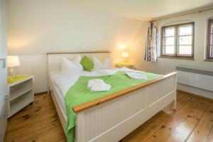 - une chambre avec un grand lit blanc et des draps verts dans l'établissement Jägerhaus auf Schloss Neuenburg, à Freyburg