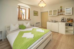a bedroom with a large bed with a green blanket on it at Jägerhaus auf Schloss Neuenburg in Freyburg