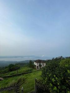 una casa sentada en la cima de una colina verde en Lovely House in Tagaytay w Pool and Taal Lake View, en Tagaytay