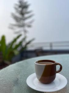 una taza de café sentada en un plato sobre una mesa en Lovely House in Tagaytay w Pool and Taal Lake View, en Tagaytay