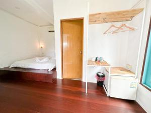 sypialnia z łóżkiem i drewnianą podłogą w obiekcie Capital O 75411 Navagio​ boutique​ Koh​ Chang​ w mieście Trat
