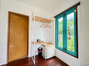 ein kleines Zimmer mit einer Tür und einem Fenster in der Unterkunft Capital O 75411 Navagio​ boutique​ Koh​ Chang​ in Trat