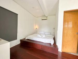 een slaapkamer met een wit bed en een groot scherm bij Capital O 75411 Navagio​ boutique​ Koh​ Chang​ in Trat