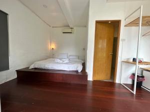 een slaapkamer met een wit bed en een houten vloer bij Capital O 75411 Navagio​ boutique​ Koh​ Chang​ in Trat