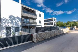 an apartment building with a stone retaining wall at Superior Apartments in Malinska