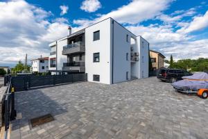 a large white building with a parking lot at Superior Apartments in Malinska +33 photos