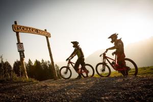 two people riding bikes on a dirt road next to a sign at Apartment Boden in Bürserberg