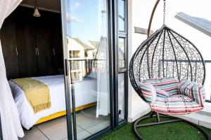 a swinging chair on a balcony with a bed at Fullmoon Two Bed Apartment in Antwerp