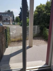 una puerta de cristal abierta con vistas a la calle en studio neuf avec terrasse, en Audincourt