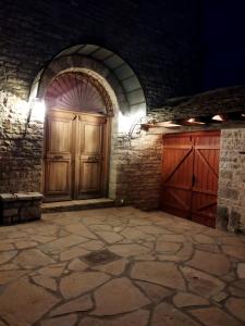 um quarto com duas portas de madeira e uma parede de tijolos em Penelope Elafotopos em Elafotopos