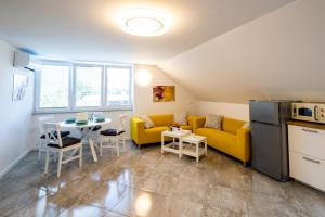 a living room with a yellow couch and a table at Aparthouse Jana Breg in Žirovnica