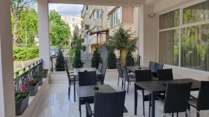 a patio with tables and chairs on a balcony at Hotel New in Baia Mare