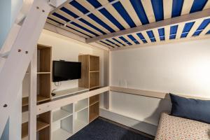 a room with a couch and a tv and a ceiling at L'Esperta - Studio proche station de ski et ESF in Eaux-Bonnes