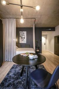 ウィーンにあるAdina Serviced Apartments Viennaのテーブル、椅子、ベッドが備わる客室です。