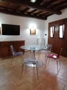 a dining room with a table and chairs and a flat screen tv at La Marchesina in Ronciglione