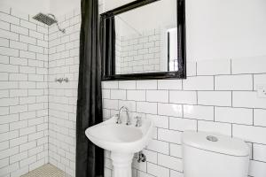 uma casa de banho branca com um lavatório e um espelho em VENUS Harbourside - FEMALE ONLY HOSTEL em Sydney
