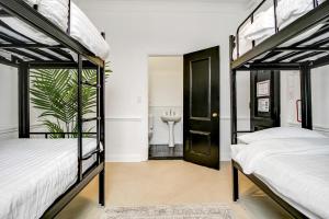 two bunk beds in a room with a bathroom at VENUS Harbourside - FEMALE ONLY HOSTEL in Sydney