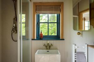 a bathroom with a sink and a window at Chatsworth Estate Holiday Cottages in Bakewell